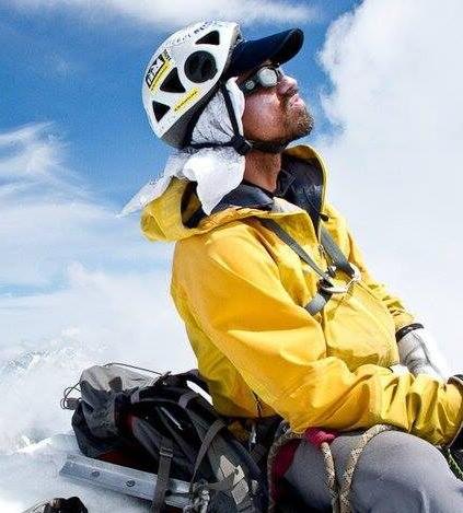 Darran Wells in his outdoor winter gear sitting in the snow.